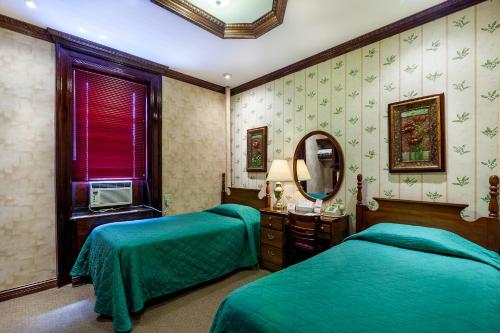 a bedroom with two beds and a mirror at Hotel 31 Extended Stay in New York