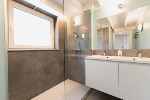 a bathroom with a sink and a shower at Boszicht 32 in De Haan
