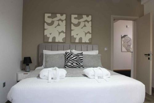 a white bed with two towels on top of it at Theasis apt in Neméa