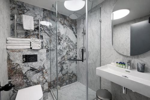 a bathroom with a shower and a sink at Deribas Hotel in Odesa