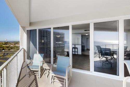 a balcony with chairs and a table and a dining room at TOPS'L Tides II in Destin