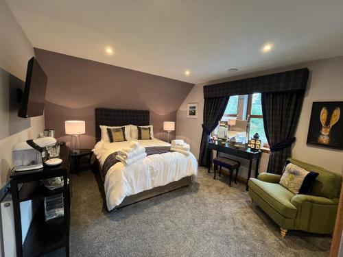 a bedroom with a bed and a chair and a desk at Copper Beeches in Elgin