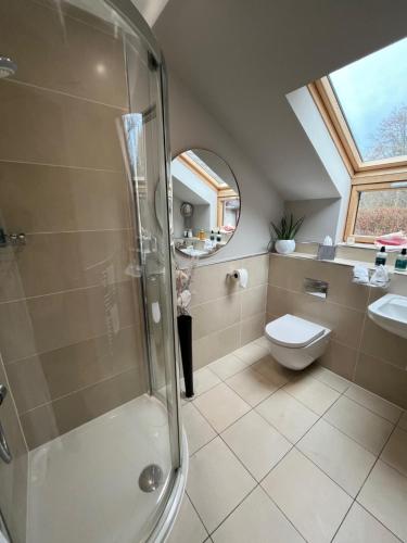 a bathroom with a shower and a toilet and a sink at Copper Beeches in Elgin
