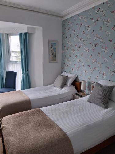 a hotel room with two beds and a window at Barbican Paignton in Paignton