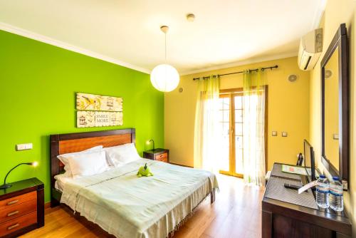 a green bedroom with a bed and a desk at Villa dos Teixos in Cascais