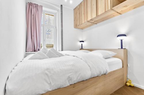 a white bedroom with a large bed with white sheets at O'Hara in Horní Blatná