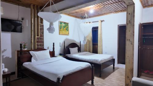 a bedroom with two beds and a flat screen tv at LUSHOTO EXECUTIVE LODGE in Lushoto