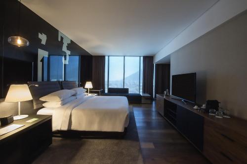 a hotel room with a bed and a television at Fiesta Americana Monterrey Pabellón M. in Monterrey
