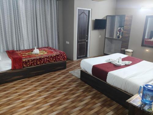 a hotel room with two beds and a table at Hotel Silver Cloud in Pelling
