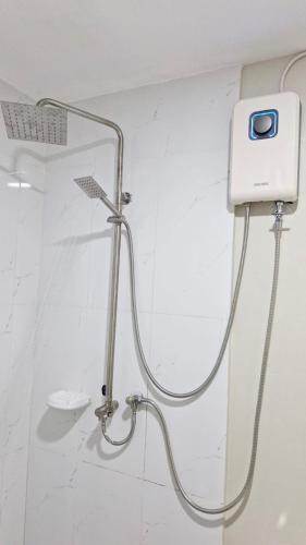a shower in a bathroom with a shower head at Priscilla Suites Mactan by Amani Grand Resort in Mactan Cebu International
