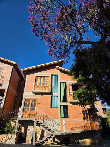 a large brick building with a staircase in front of it at Chalé Sol - Vila Doiideira - lindo aconchegante e no centro de Ibitipoca in Lima Duarte