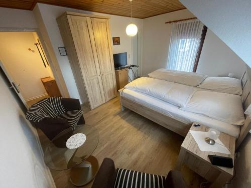ein kleines Schlafzimmer mit einem Bett und einem Tisch in der Unterkunft Mariennest in Jever