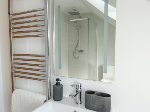 a bathroom with a sink and a shower at Hen Siop in Llanfairpwllgwyngyll