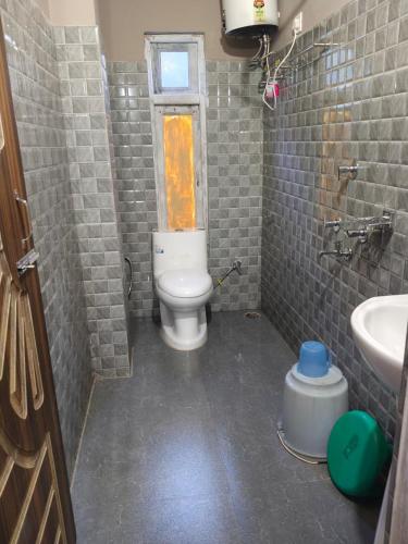 a small bathroom with a toilet and a sink at Hotel Silver Cloud in Pelling