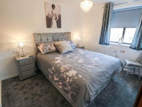 a bedroom with a bed and a chair and a window at Cha Cha's Cottage in Whitby