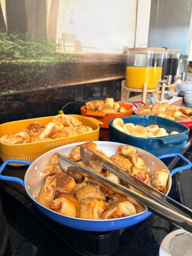 a group of trays of food on a counter at Hotel Cittari Tatuí in Tatuí