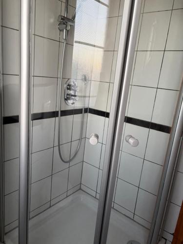 a shower with a glass door in a bathroom at Hotel Tristan Grün in Rheine