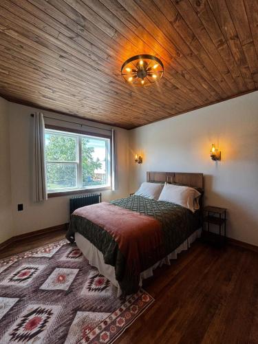 ein Schlafzimmer mit einem Bett und einer Holzdecke in der Unterkunft Twin Cities Hotel in Turner Valley