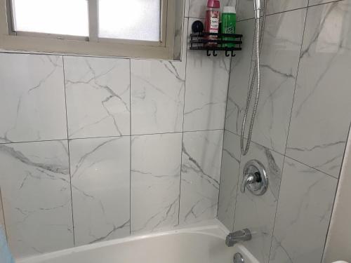 a bathroom with a shower with white marble tiles at Bachome in Kettering