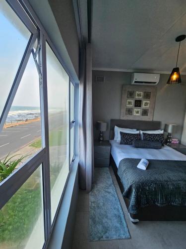 a bedroom with a bed and a large window at Umdloti Luxe Horizon in Umdloti