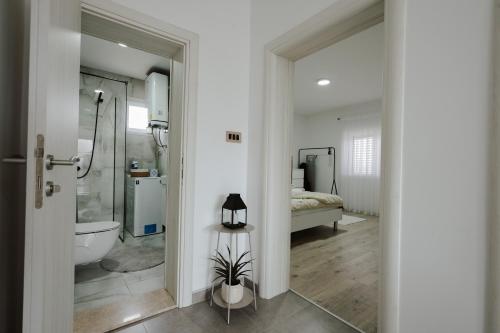 a bathroom with a shower and a toilet and a bed at Guest house Ivan in Međugorje