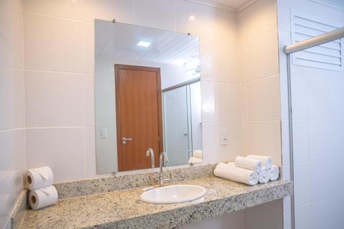 a bathroom with a sink and a mirror at Portobello Park Hotel in Porto Seguro