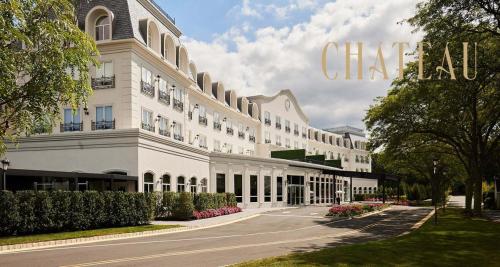 a large white building with a sign that reads chase hotel at The Chateau Grande Hotel in East Brunswick