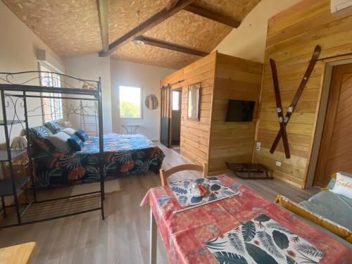a room with two beds and a table in it at Chambre Ephédra in Sampzon