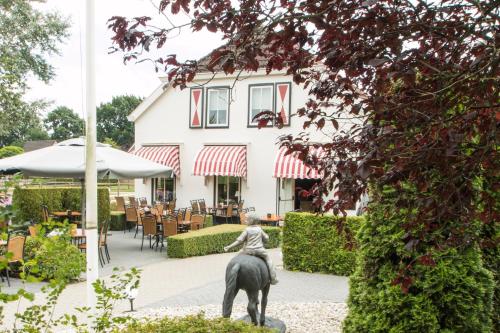a statue of a woman riding a horse in front of a building at Hotel Restaurant Eeserhof in Ees