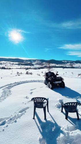 two benches sitting in the snow next to a snowmobile at Panorama Residence Ivan in Pljevlja
