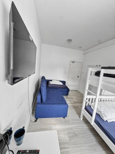 a room with two bunk beds and a flat screen tv at 6 Guest Room in Zone 2 - Willesden Green in London