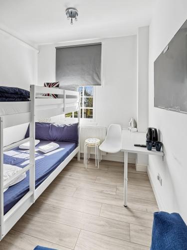 a dorm room with bunk beds and a desk at 6 Guest Room in Zone 2 - Willesden Green in London