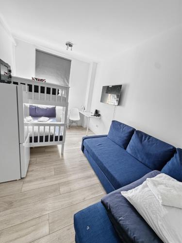 a living room with a blue couch and a crib at 6 Guest Room in Zone 2 - Willesden Green in London