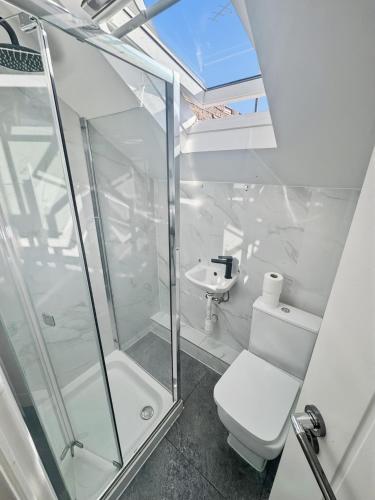 a bathroom with a shower and a toilet and a sink at 6 Guest Room in Zone 2 - Willesden Green in London