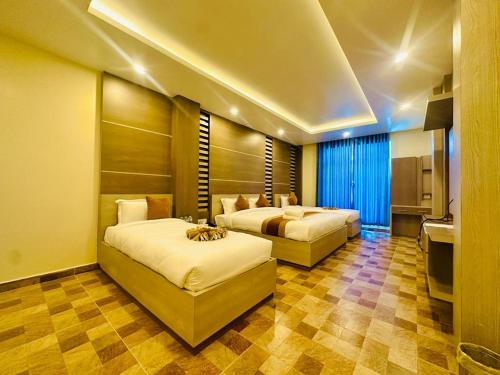 ein Schlafzimmer mit zwei Betten und einer Küche darin in der Unterkunft Hotel Reborn in Sanwal