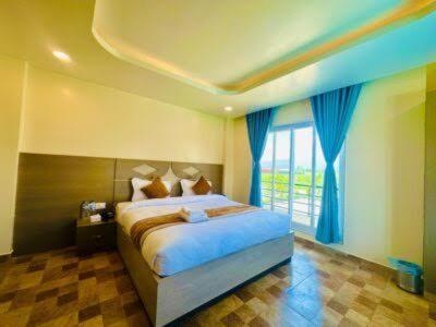 ein Schlafzimmer mit einem Bett und einem großen Fenster in der Unterkunft Hotel Reborn in Sanwal