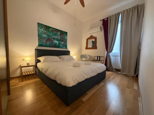 a bedroom with a bed with a painting above it at I Maltesi apartment in Sassari