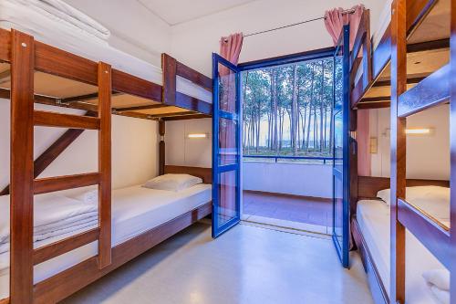 a dorm room with bunk beds and a window at HI Ovar - Pousada de Juventude in Ovar