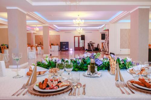 a long table with plates of food on it at Hotel Rao in Cluj-Napoca