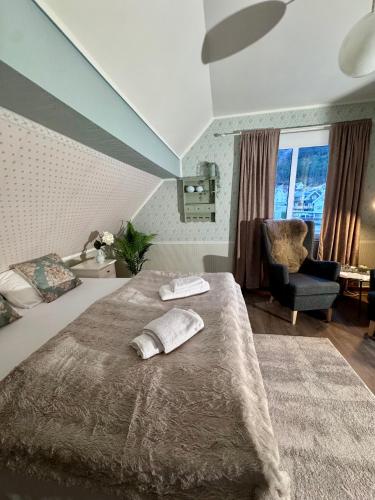 a bedroom with a bed and a chair and a window at Villa Utsikten Eggen in Åndalsnes