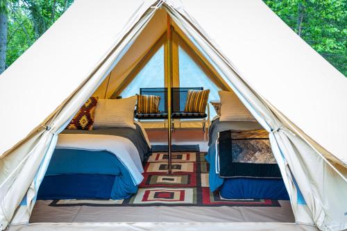 a tent with two beds and a chair in it at Goonieland Backcountry Sauna & Stays in Golden
