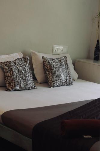 a bed with three pillows on top of it at Calathea home varkala beach in Varkala