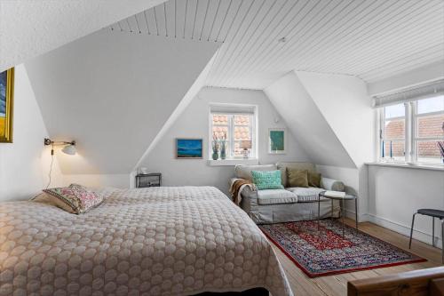 a bedroom with a bed and a couch and a window at AE318-Marstal-Faergestraede-45 in Marstal