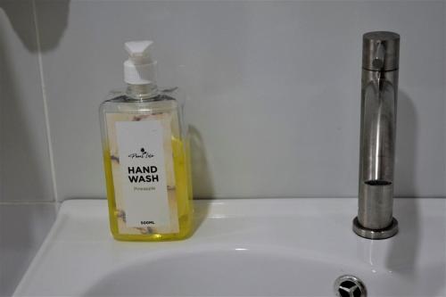 a bottle of hand wash sitting on top of a sink at Lilac cottage in Gatunga