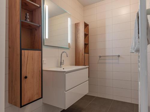 a white bathroom with a sink and a shower at Het Havenverblijf in Kamperland
