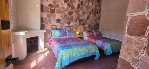 a bedroom with two beds and a fireplace at Sandy Shores Cabaña 5 in La Paz