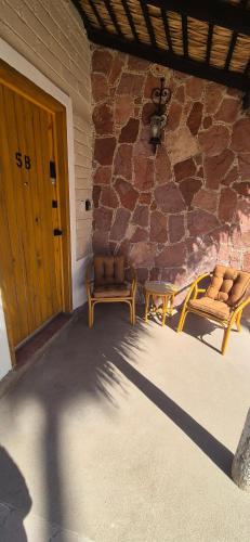 a patio with two benches and a stone wall at Sandy Shores Cabaña 5 in La Paz