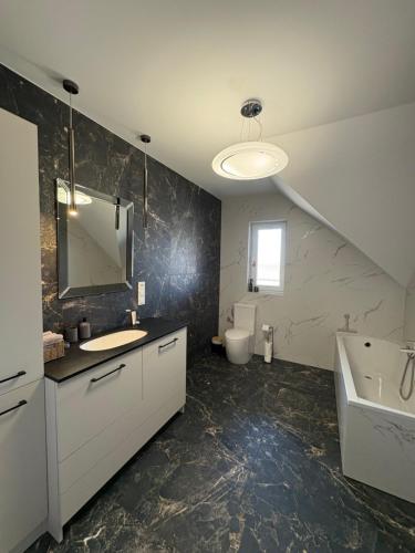 a bathroom with a sink and a tub and a toilet at Biebrzańska Dolina 1 in Goniadz