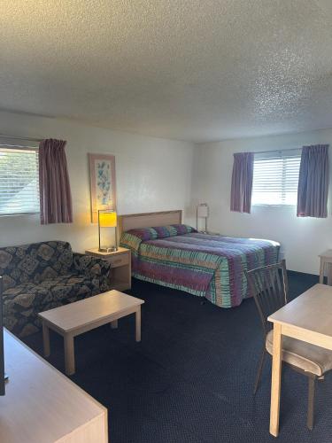 a hotel room with a bed and a couch at Flamingo Suites in Tucson