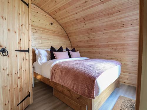 a bedroom with a bed in a wooden cabin at Cennin Pedr in Ruthin